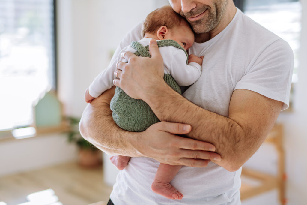 Man holding baby in his arms gently