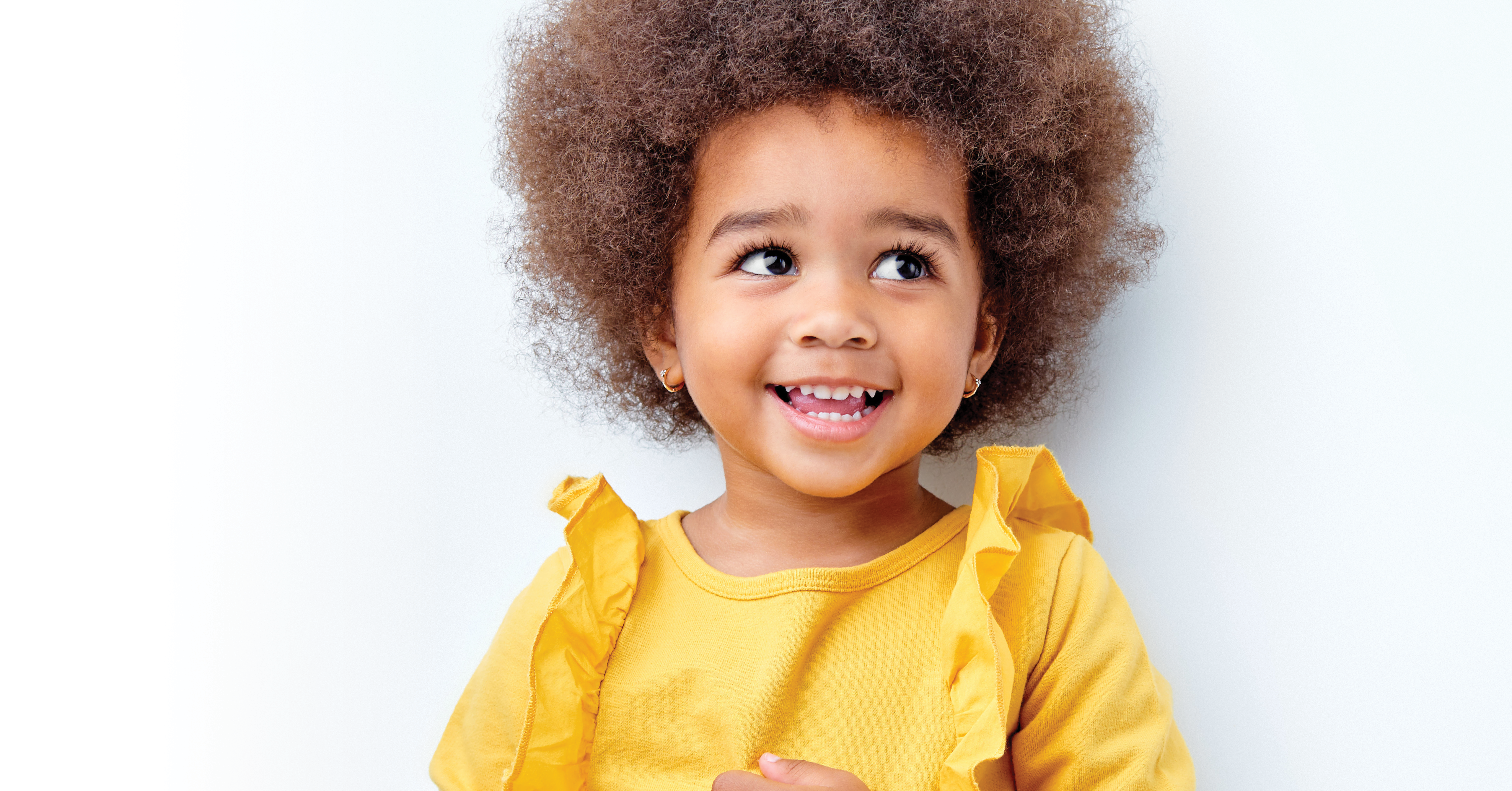 Happy toddler girl in yellow blouse