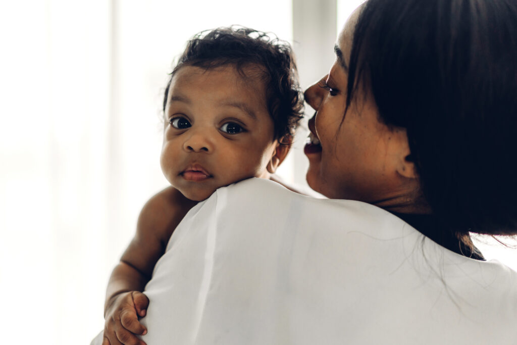 Mother holding a baby in her arms in bedroom
