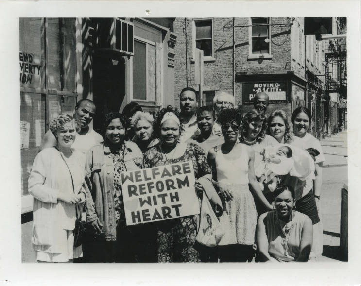 Group holding sign “Welfare Reform with Heart” on sidewalk in Cincinnati, Ohio. (Source: Cincinnati & Hamilton County Public Library. Genealogy and Local History Department)