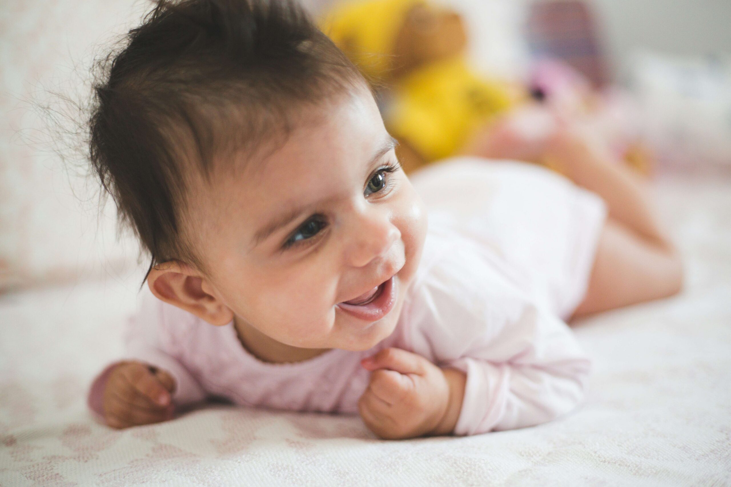 Baby smiling on mat for tummy time