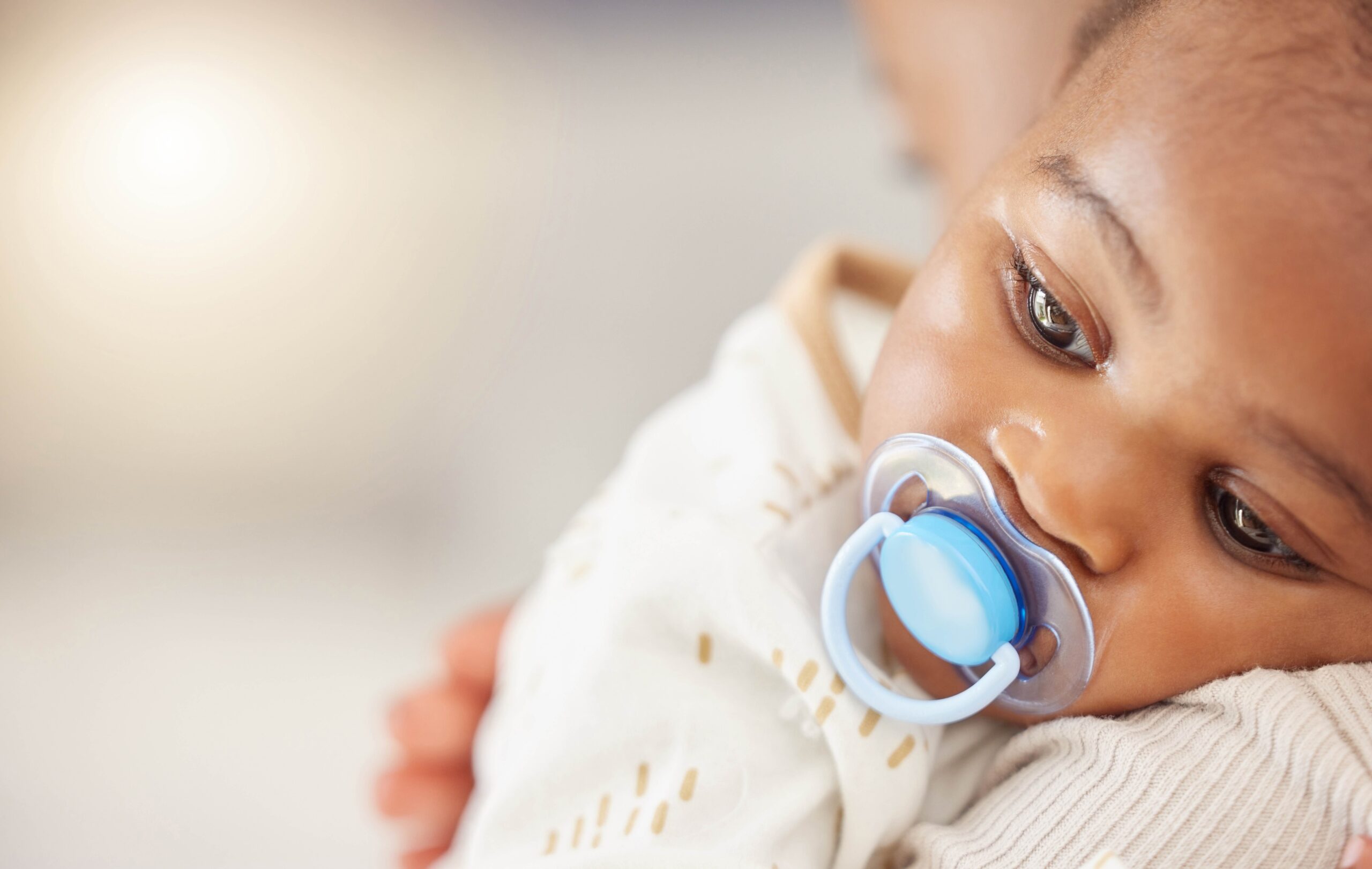 Baby resting on a caregiver's shoulder