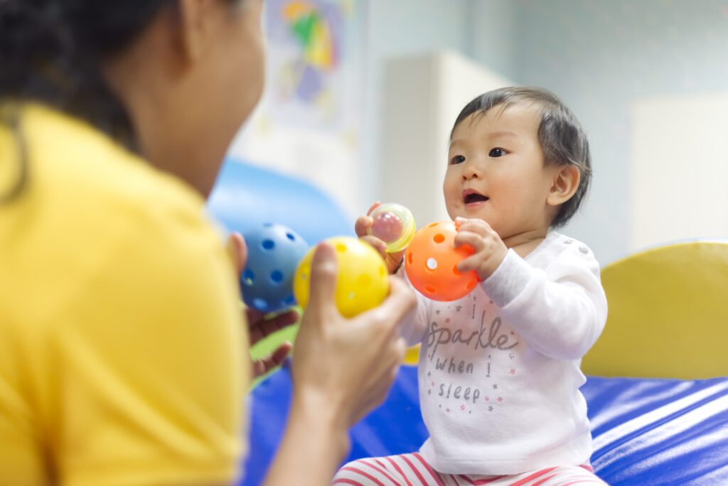 Baby playing with caregiver