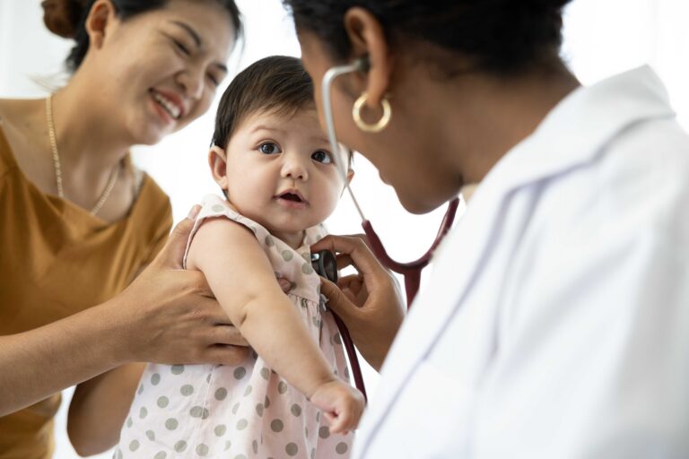 Baby with caregiver being seen by the doctor