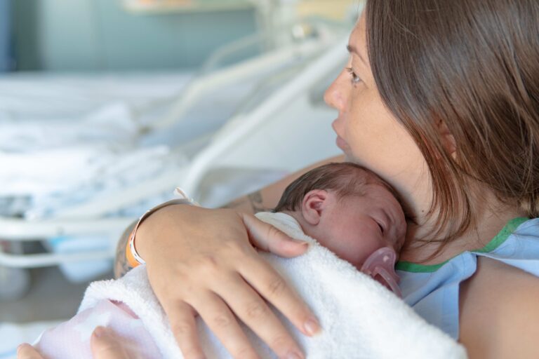 Mother holding baby close to her chest after delivery
