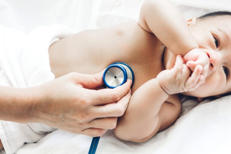 Doctor listening to baby's chest with stethoscope
