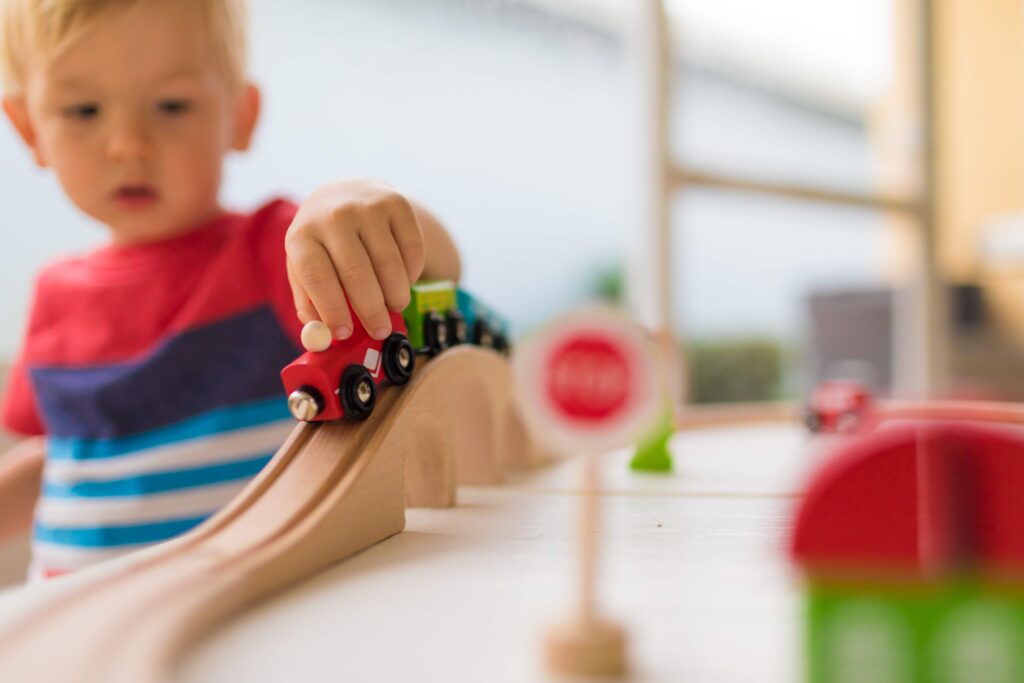 Little boy playing with toy train.