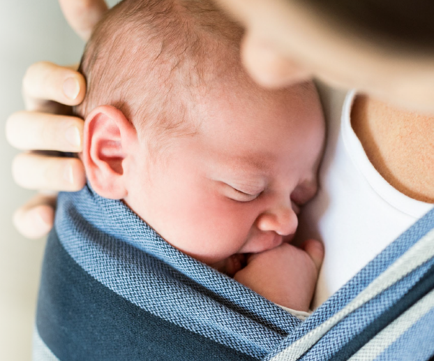 Baby held close to their mother's chest