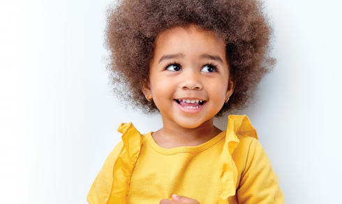 Happy toddler girl in yellow blouse