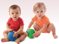 Babies in colorful onesies sitting side by side