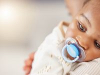 Baby resting on a caregiver's shoulder