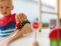 Little boy playing with toy train.